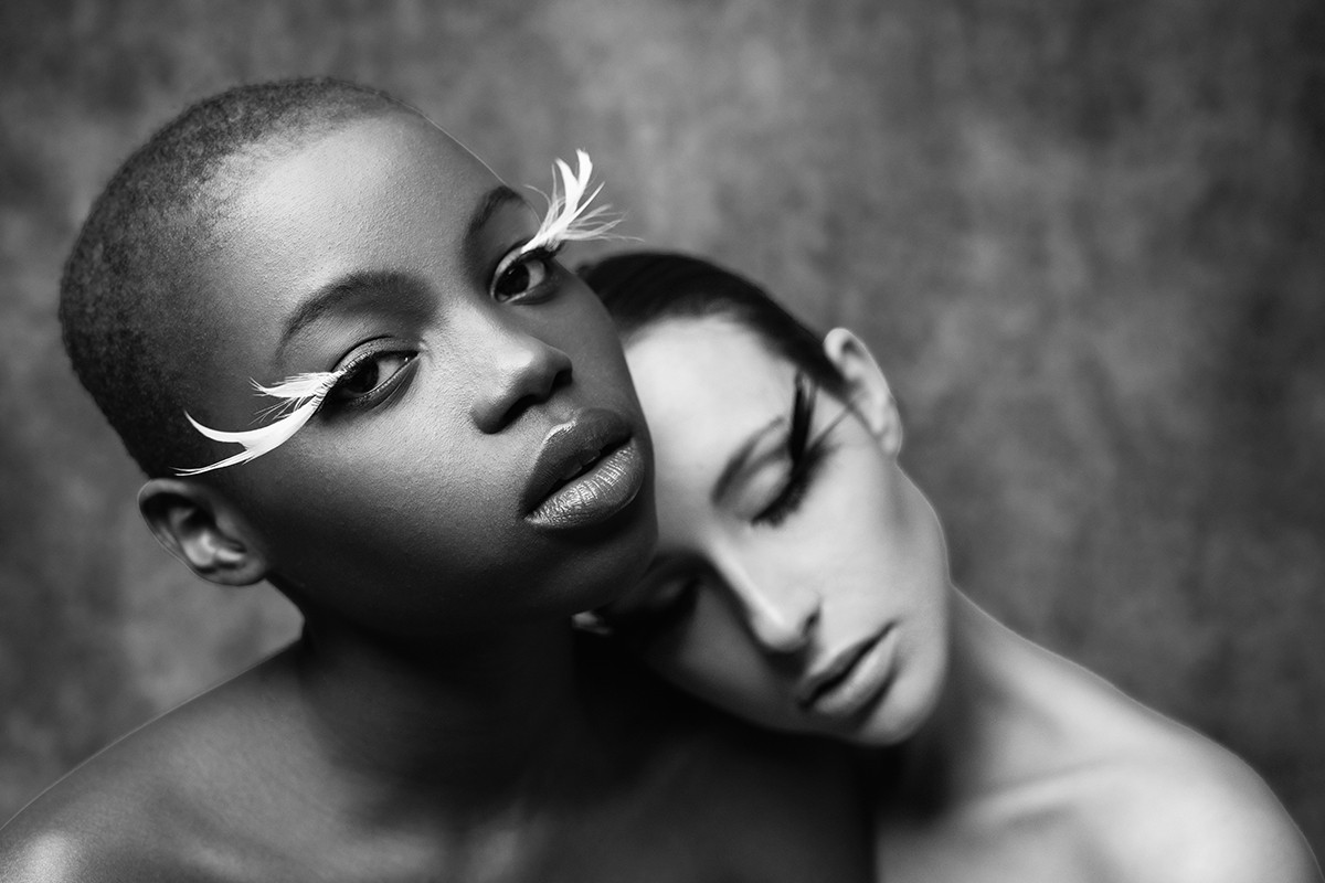 Fallen Angels series black and white portrait of two figures with feather lashes