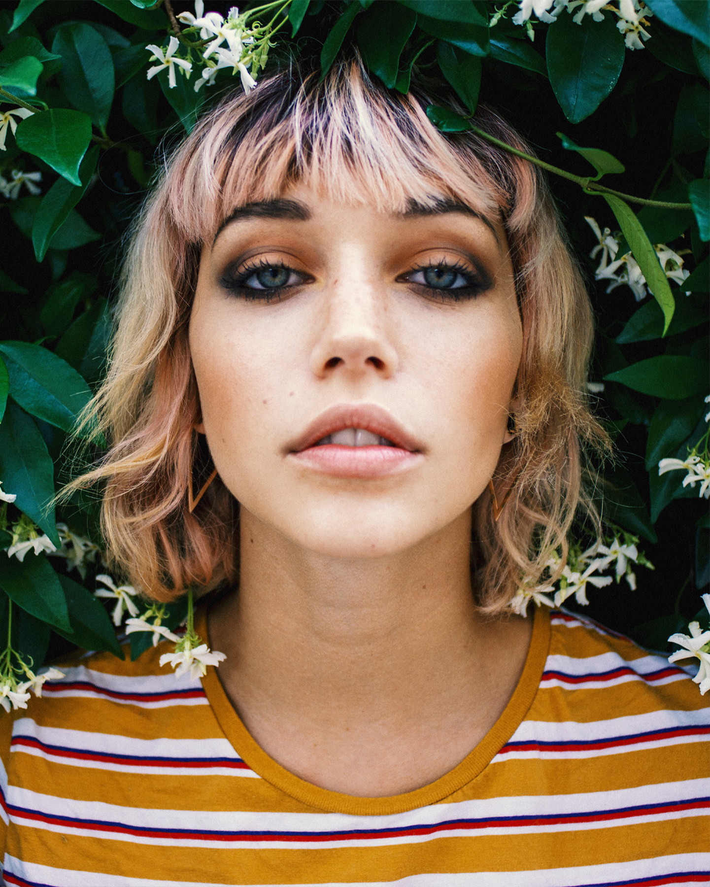 Editorial portrait framed by foliage