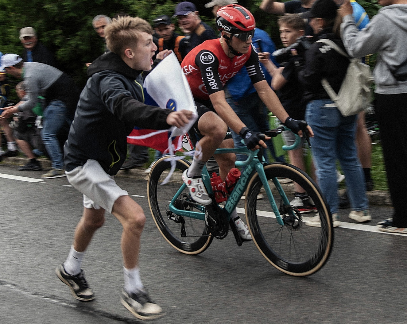 Road cyclist riding through a dense crowd