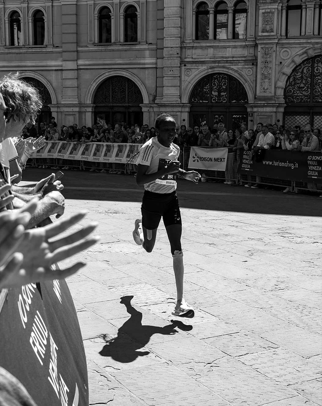 Runner approaching the finish in black and white