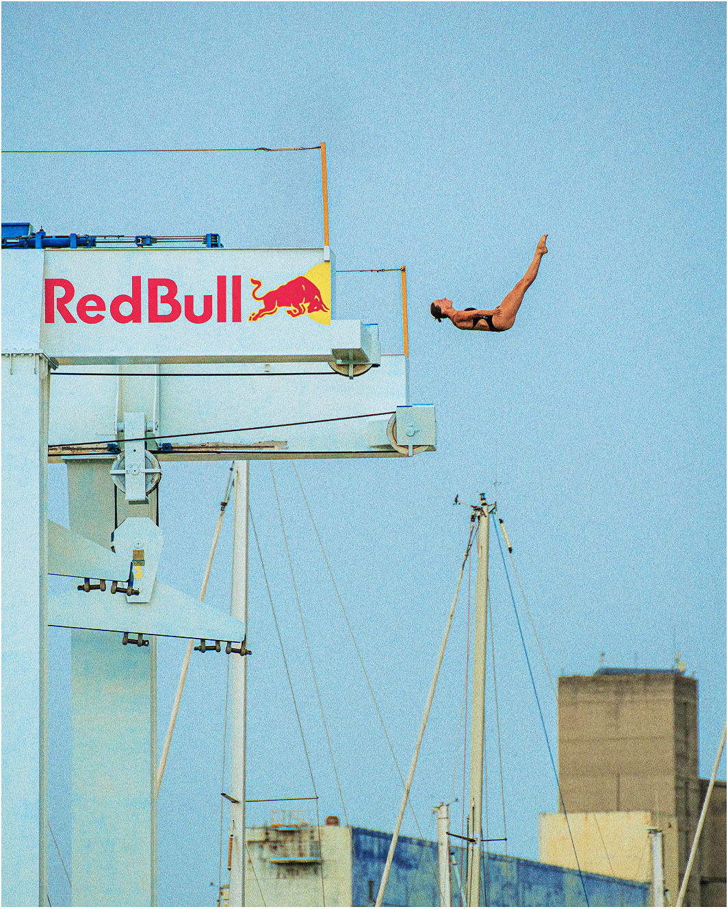 Diver in the air beside an industrial diving platform